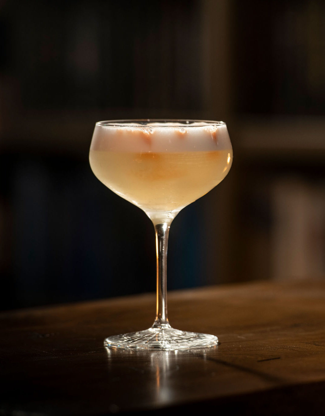 Peach Cocktail in Coupe Glass on bar 