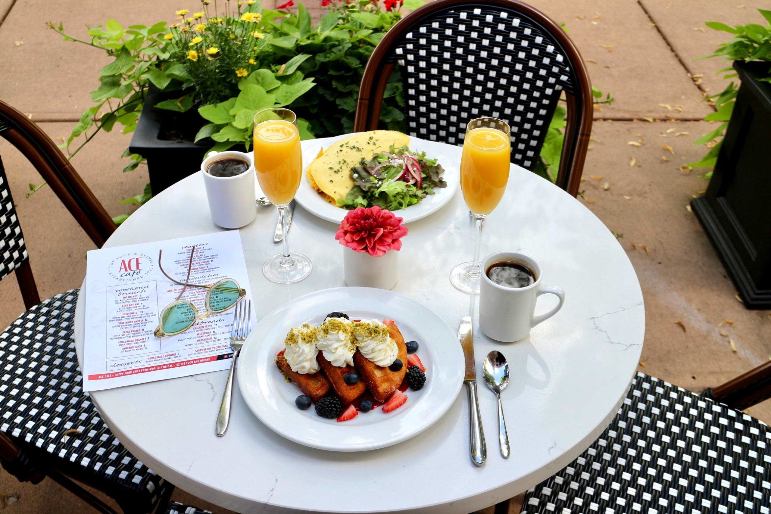 Ace Cafe patio table with brunch items, coffee, and juice