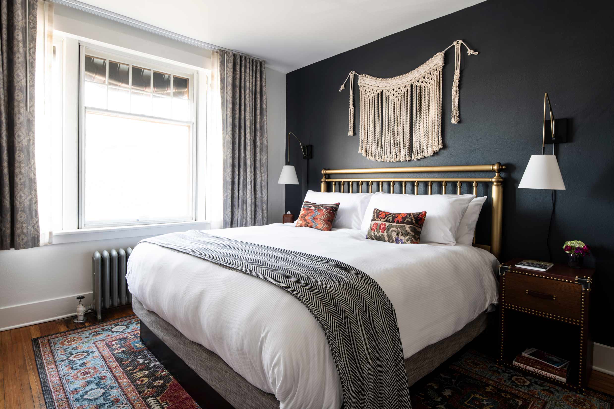 Side view of bed with macrame wall hanging and a bright window