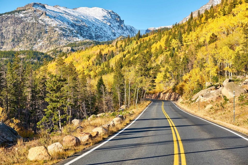 Rocky mountain drive with yellow foliage and snowcapped mountains