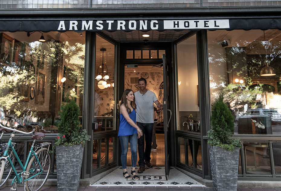 Couple walking out of entrance to Armstrong hotel 