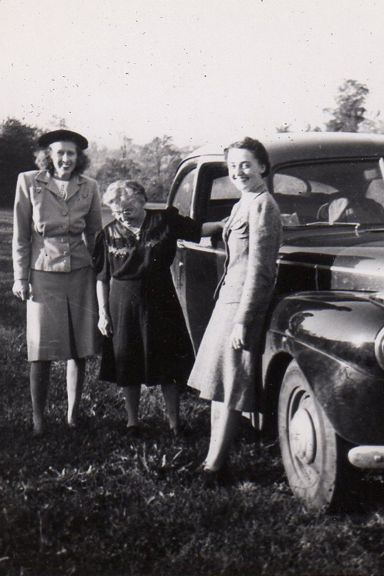 Historical photo of 3 women next to a vintage car
