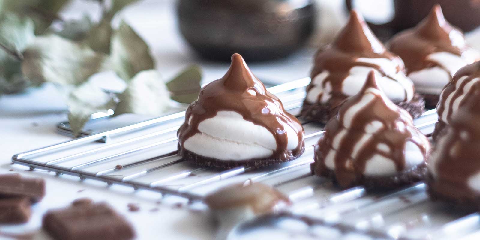 Chocolate drizzled marshmallow kisses on chocolate wafer