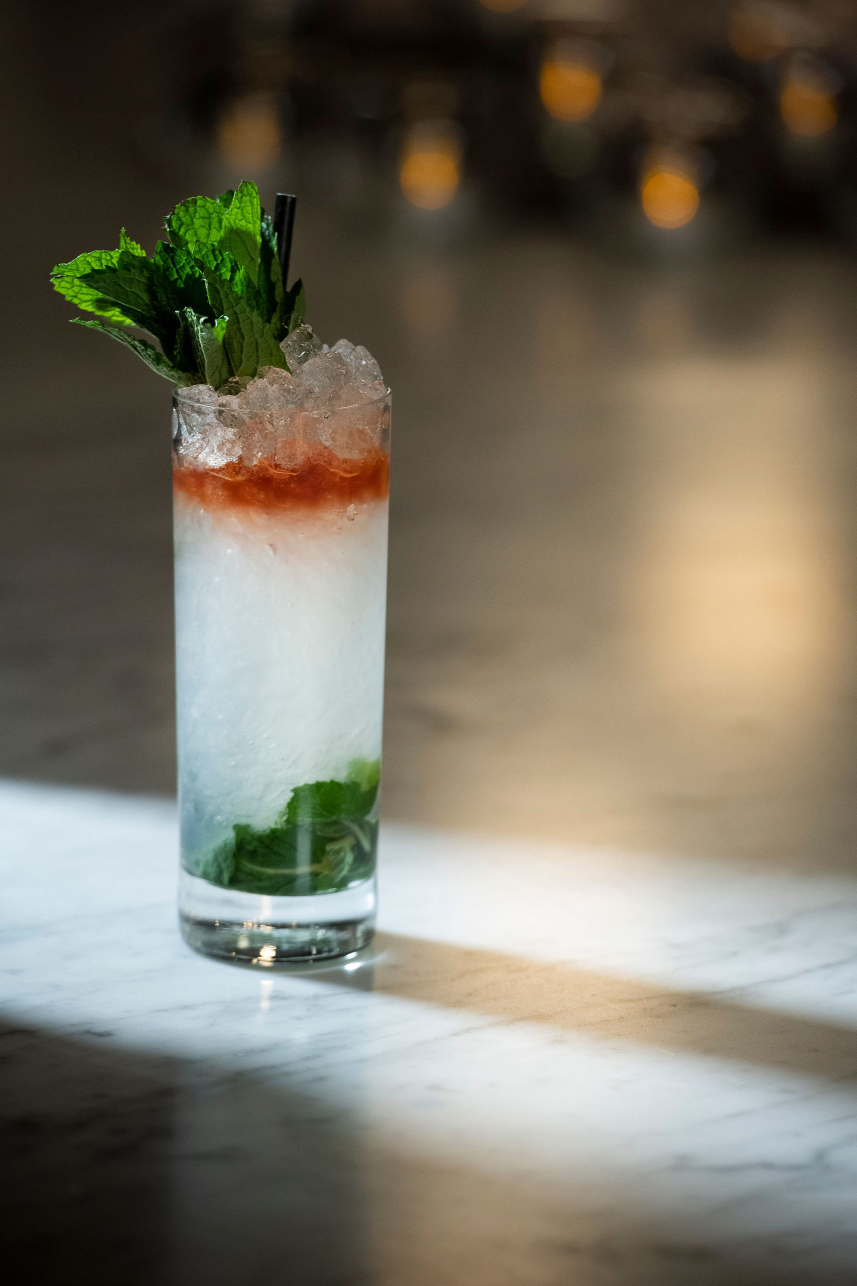 White and red cocktail on bar with mint leaves 