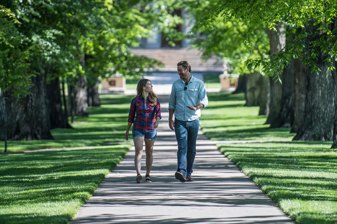 Couple walking through CSU Oval in summer