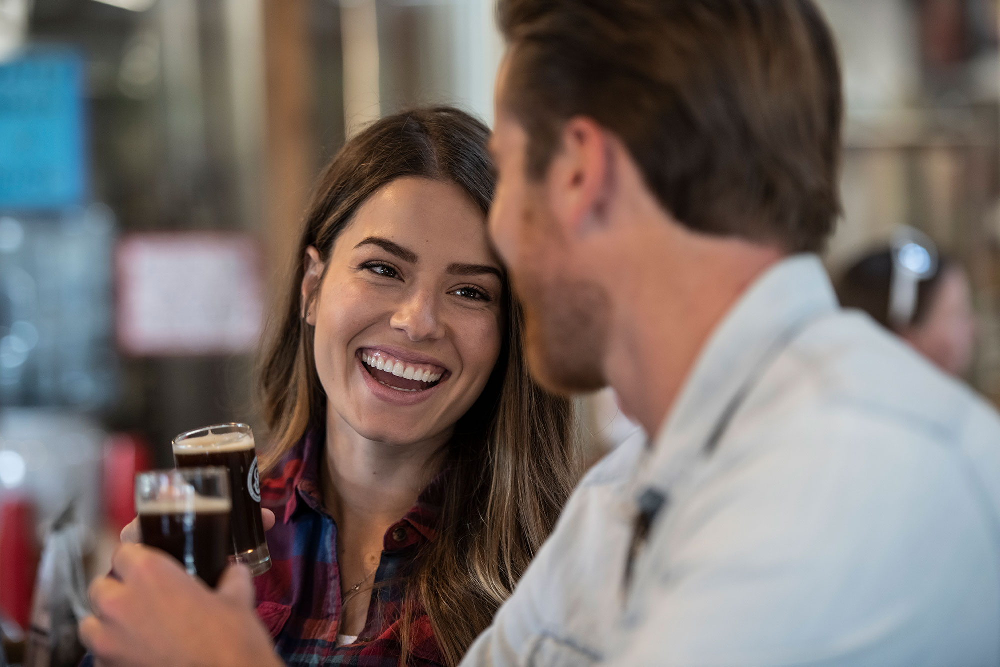 Couple smiling with flight taster beer glasses